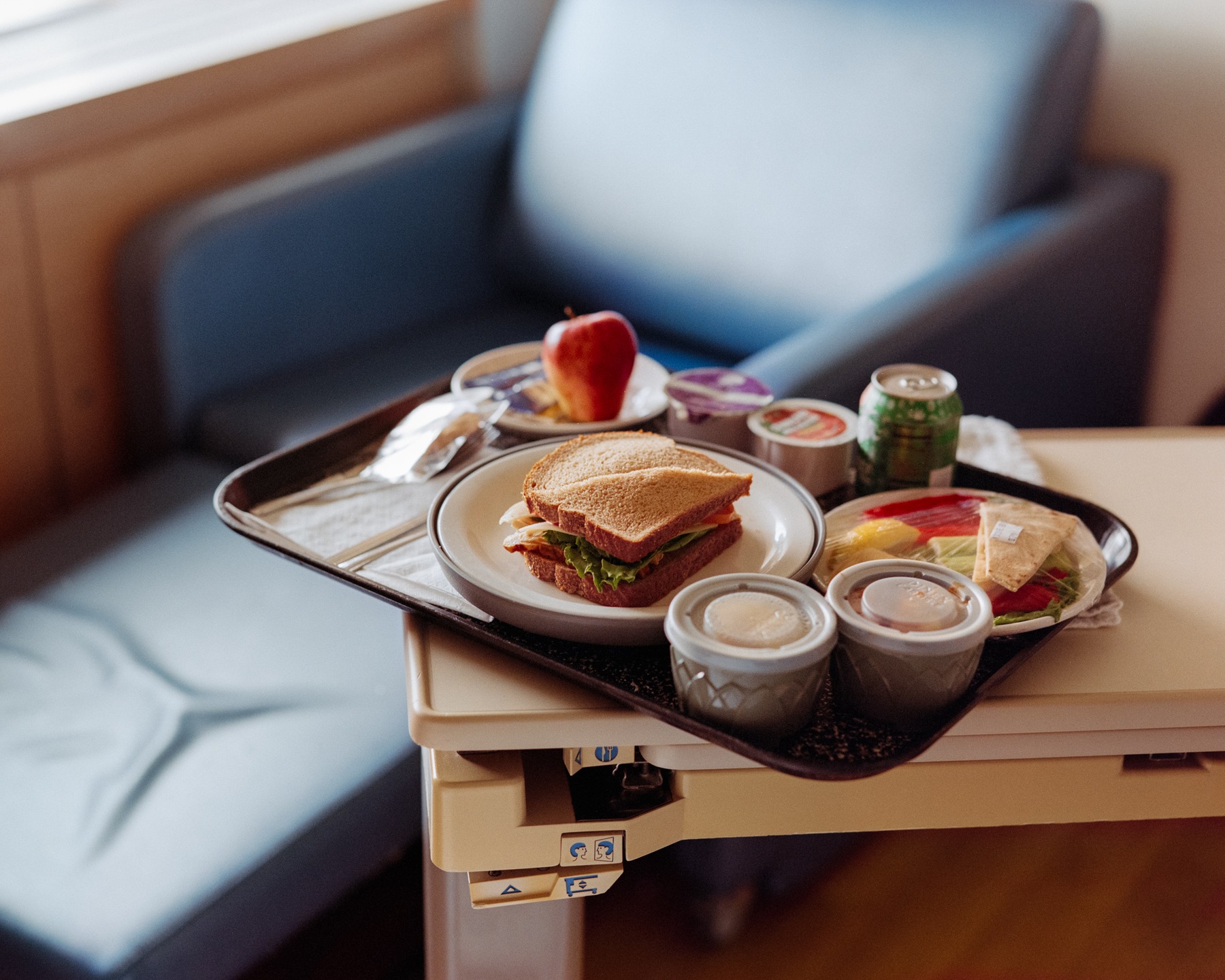 A meal on a tray beside an armchair