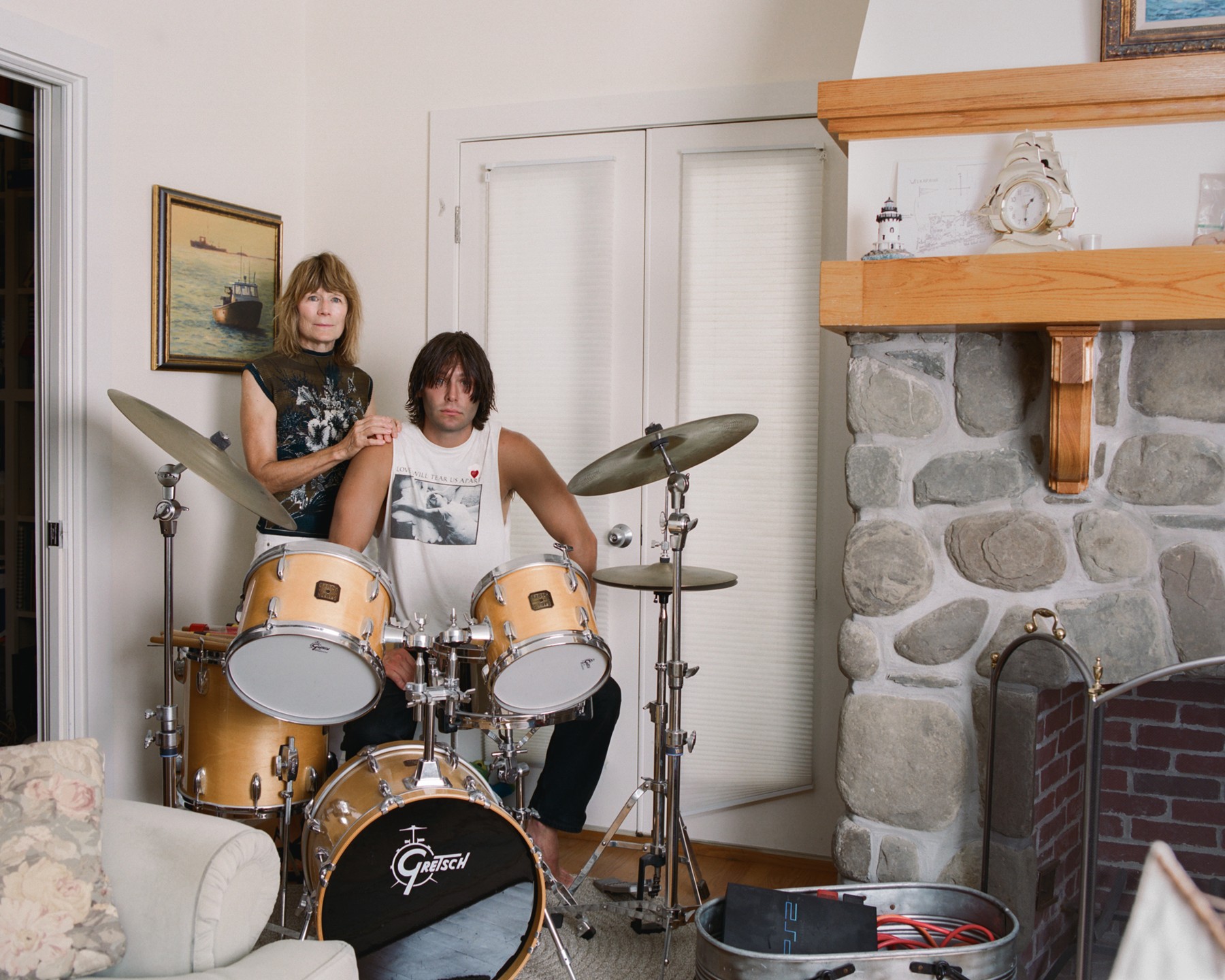 Two children with a drum kit in a living room