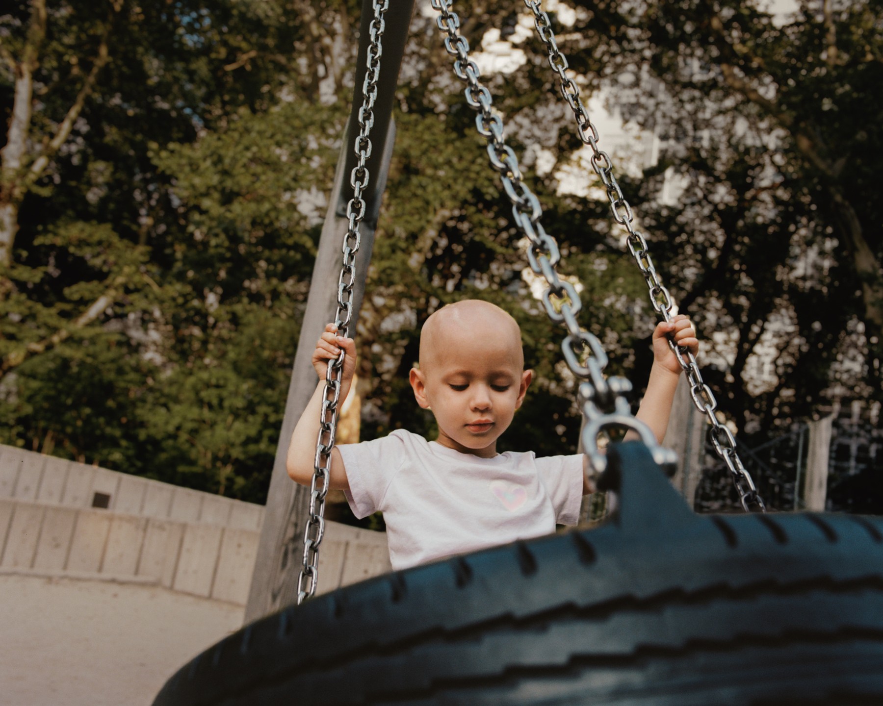 A baby sitting in an outdoor swing