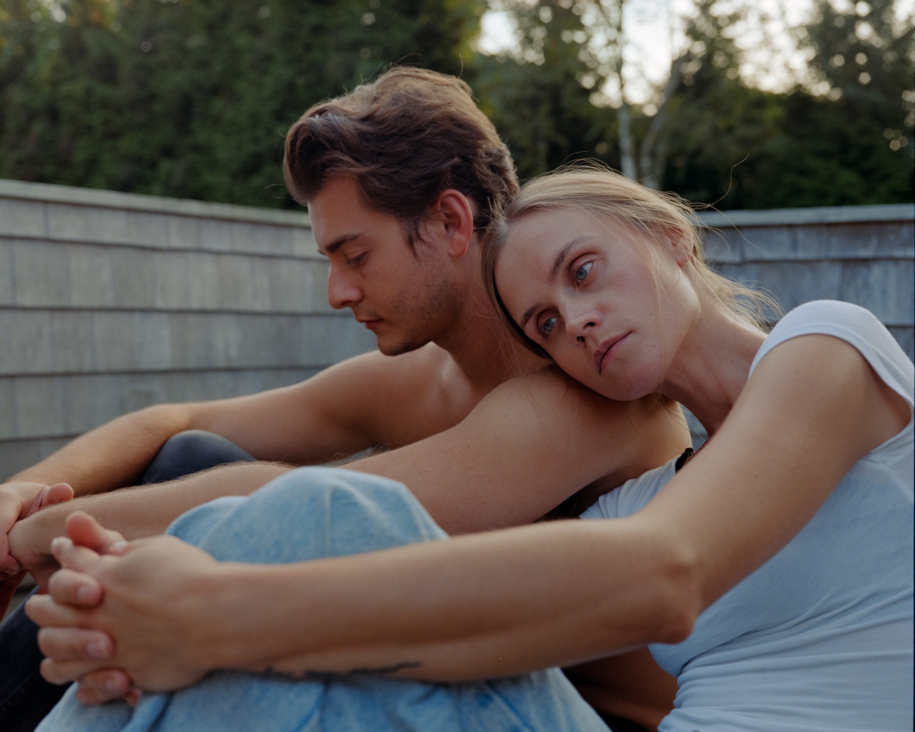 A couple sitting closely together outside